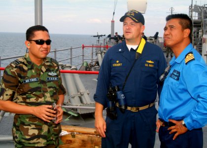 US Navy 070709-N-0120A-029 Cmdr. David L. Bossert, dock landing ship USS Harpers Ferry (LSD 49) commanding officer, discusses the ship's satellite communication capabilities with a Royal Malaysian Air Force officer and a