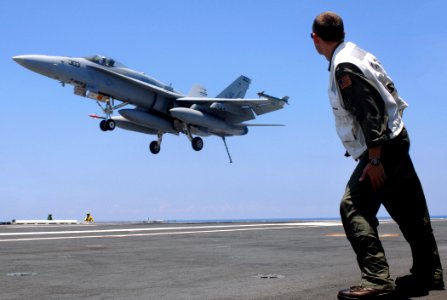 US Navy 070709-N-2984R-003 A landing signal officer watches as an F-A-18C Hornet, assigned to The Raging Bulls of Strike Fighter Squadron (VFA) 37, approaches the flight deck during flight operations on board Nimitz-class aircr