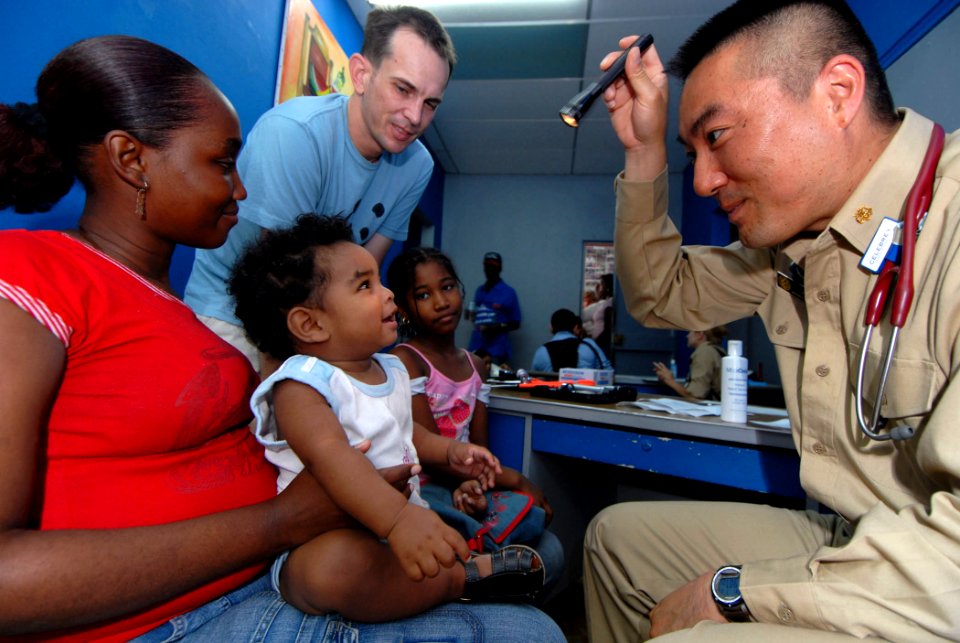 US Navy 070706-N-8704K-090 Lt. Cmdr. Harry Ko, U.S. Public Health Service attached to Military Sealift Command hospital ship USNS Comfort (T-AH 20), provides medical care at the Paul Brown Arena photo