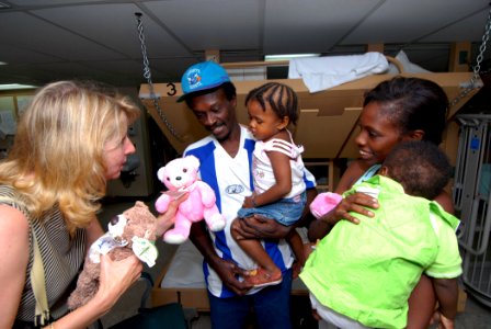 US Navy 070709-N-8704K-012 Mrs. Laura Stavridis, wife of Commander, U.S. Southern Command, Adm. James Stavridis, gives bears donated by Hugs Across America to a young child aboard the Military Sealift Command hospital ship USNS