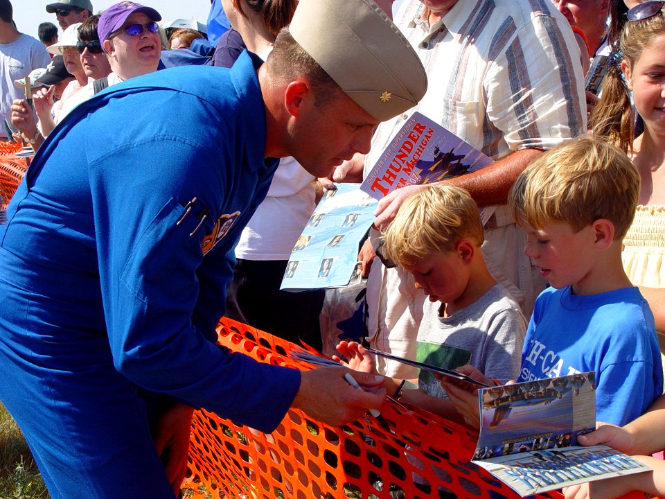 US Navy 070707-N-2888Q-001 Marine Corps Maj. Nathan Miller, a Blue Angels pilot, signs autographs for young fans following a performance at the Thunder Over Michigan Air Show
