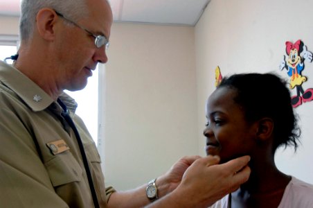 US Navy 070705-N-6278K-044 Cmdr. Arne Anderson, a pediatrician attached to Military Sealift Command hospital ship USNS Comfort (T-AH 20), inspects a patient's lymph nodes at the Dr. Juan A. Nunez Policentro de Salud Hospi