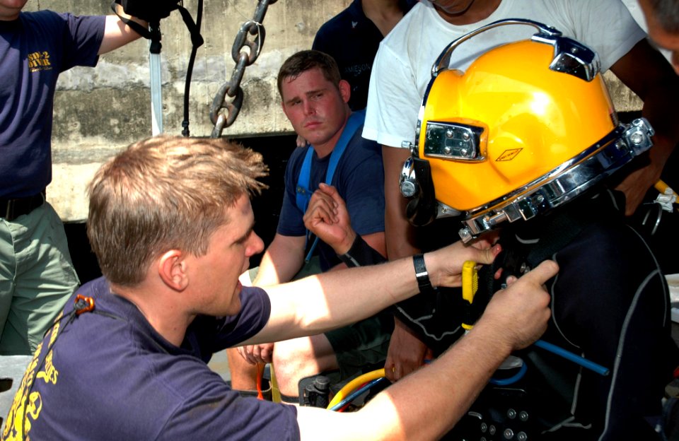 US Navy 070708-N-7783B-002 Navy Diver 2nd Class Nathan Kralemann, of Mobile Diving and Salvage Unit One Det. 11, helps a Royal Malaysian Navy mine warfare diver secure his diver's helmet