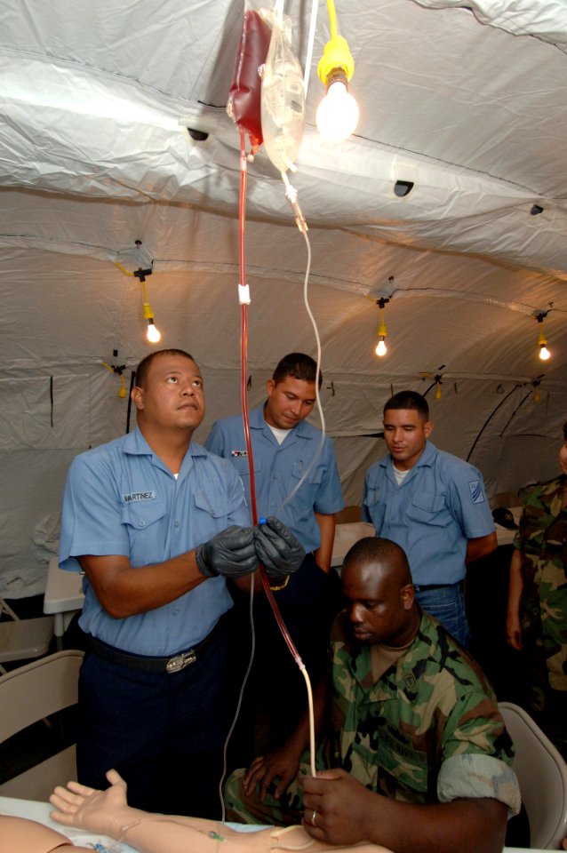 US Navy 070712-N-0989H-053 Hospital Corpsman 1st Class Charles Givens, Task Group 40.9 independent duty corpsman, and interpreter Master-at-Arms 1st Class Hector Cardona demonstrate the proper procedures for administering an IV
