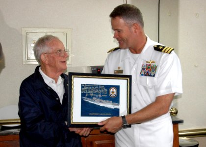 US Navy 070705-N-8497H-244 Cmdr. Jon Kreitz, commanding officer of guided-missile frigate USS Stephen W. Groves (FFG 29), presents Dr. Richard Groves, the brother to the ship's namesake, a signed picture of the ship photo