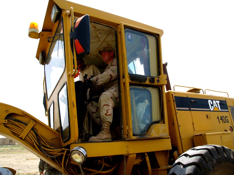 US Navy 070707-N-3385W-086 U.S. Navy Cmdr. David Adams, commanding officer of Provincial Reconstruction Team Khost, drives a grader for the first few meters of a groundbreaking ceremony