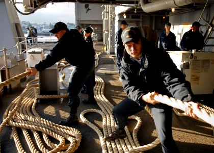 US Navy 070707-N-7981E-028 Seaman Jacob Albon and members of deck department single up lines as Nimitz-class aircraft carrier USS Abraham Lincoln (CVN 72) gets underway from her home port photo