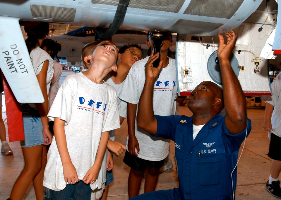 US Navy 070711-N-1082Z-003 Aviation Machinist's Mate 1st Class Todd Thomas, assigned to the Tomcatters of Strike Fighter Squadron (VFA) 31, shows children from the Drug Education For Youth (DEFY) summer camp various aspects of
