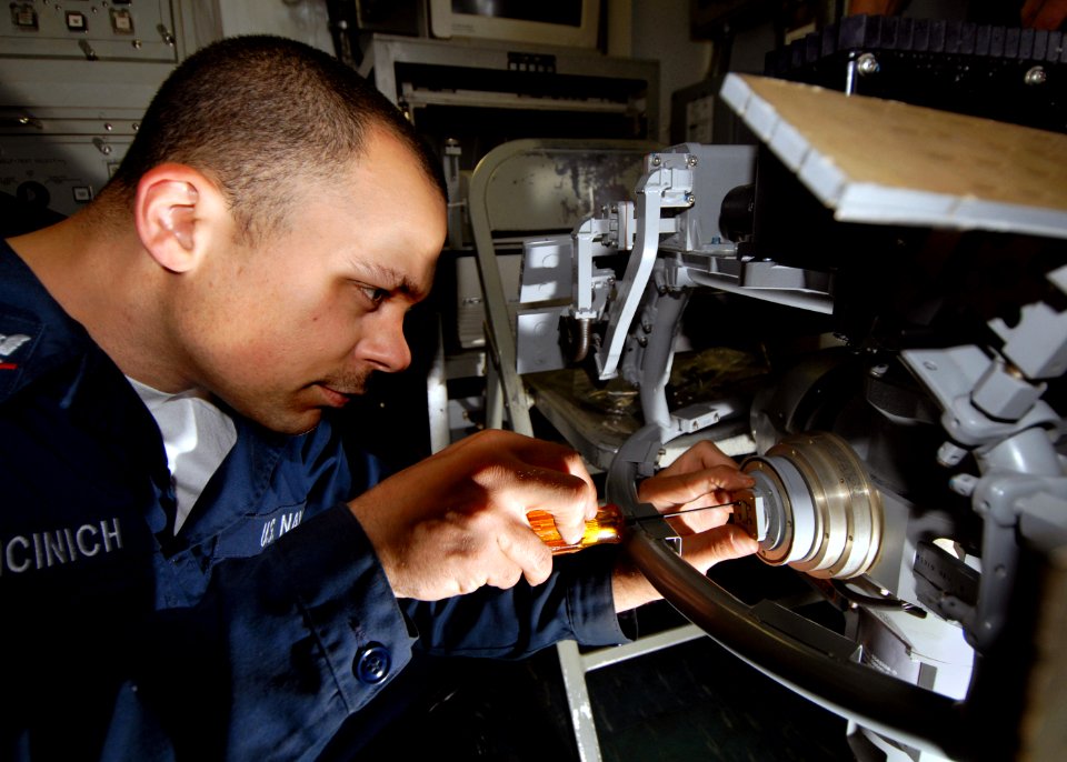 US Navy 070714-N-7981E-014 Fire Controlman 3rd Class Anthony Picinich, assigned to Combat Systems Department, performs repairs on the gimbal motor of a phase array search antenna for the ship's close in weapons system