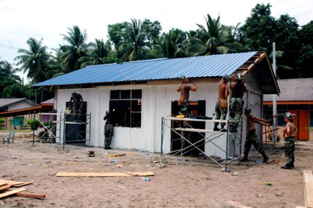 US Navy 070709-N-7783B-003 After a ten-day engineering civic action project, members of Naval Mobile Construction Battalion (NMCB) 7 and the Royal Malaysian Army Engineers put the finishing touches on a $20,000 new school house photo