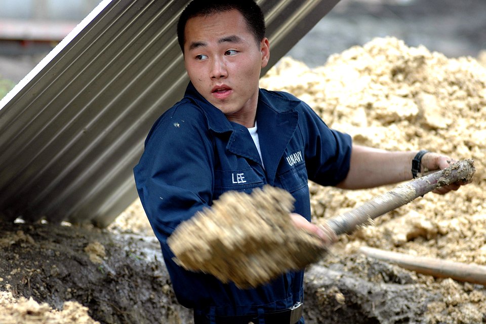 US Navy 070707-N-9421C-064 Aviation Boatswain's Mate (Fuel) Airman Paochoua Lee digs a ditch for a septic tank for one of the homes being built at Honest Anislag Transition Center in support of Pacific Partnership 207