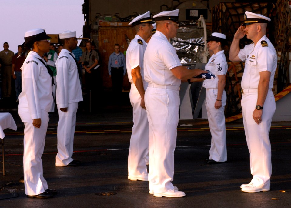 US Navy 070707-N-3080T-003 Lt. Cmdr. Jack Knick salutes Command Master Chief James Philip Russell during a burial at sea for retired Chief Boiler Technician John Freeman and retired Cmdr. James Gilbert aboard Nimitz-class aircr