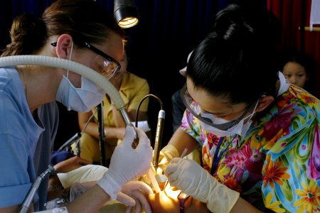US Navy 070716-N-9195K-058 Hospital Corpsman 2nd Class Laura Blanco, assisted by Aviation Ordnanceman 3rd Class Ashley Cameron, cleans a child's teeth during a dental civic action program conducted in support of Pacific P