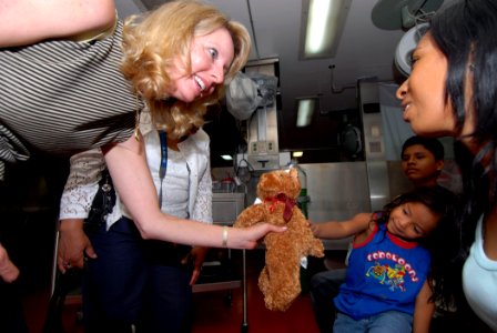 US Navy 070709-N-8704K-018 Mrs. Laura Stavridis, wife of Commander, U.S. Southern Command, Adm. James Stavridis, gives a stuffed animal donated by Hugs Across America to a young child aboard the Military Sealift Command hospita