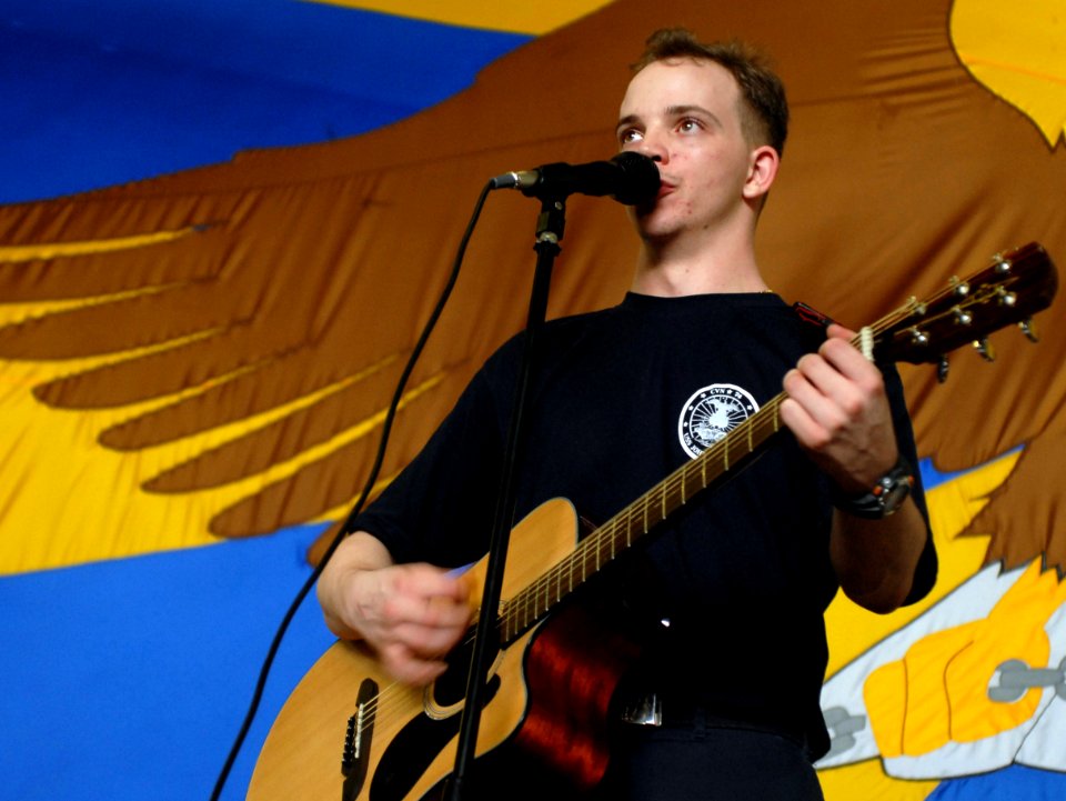 US Navy 070710-N-3541A-133 Airman Recruit John Croft plays guitar and sings during a battle of the bands in the hanger bay aboard Nimitz-class aircraft carrier USS John C. Stennis (CVN 74)