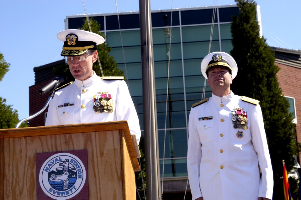 US Navy 070711-N-3390M-003 Rear Adm. James Symonds reads his orders as the new commander of Navy Region Northwest while Rear Adm. William French looks on during a change of command ceremony at Jackson Plaza on board Naval Stati