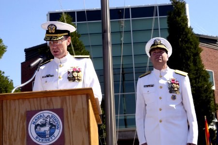 US Navy 070711-N-3390M-003 Rear Adm. James Symonds reads his orders as the new commander of Navy Region Northwest while Rear Adm. William French looks on during a change of command ceremony at Jackson Plaza on board Naval Stati