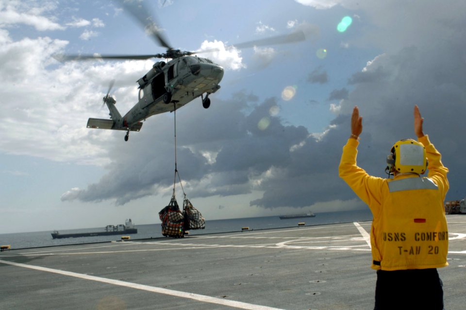 US Navy 070718-N-7088A-226 Aircrew personnel assigned to Helicopter Sea Command (HSC) Squadron 28 assist in directing an MH-60S Seahawk helicopter in moving cargo aboard Military Sealift Command hospital ship USNS Comfort (T-AH