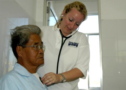 US Navy 070718-N-6410J-018 Project Hope volunteer Diana Bennett checks the heart beat of a Vietnamese patient during a medical civil action program in support of Pacific Partnership 2007