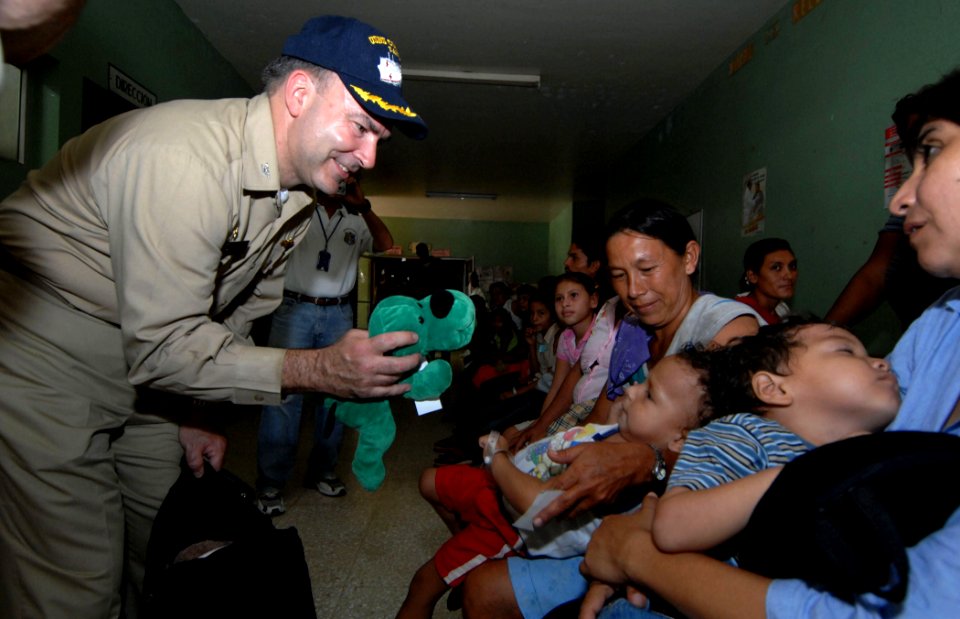 US Navy 070719-N-0194K-408 Capt. Bob Kapcio, mission commander aboard the Military Sealift Command hospital ship USNS Comfort (T-AH 20), hands out stuffed animals during a tour of the Jose Schendal Health Center