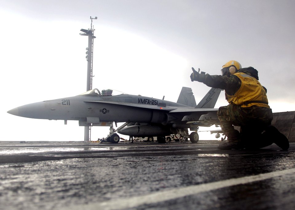 US Navy 070713-N-8132M-081 Aviation Boatswain's Mate (Handling) 3rd Class Terry Keyes passes control of the launch of an F-A-18C Hornet, attached to the Checkmates of Strike Fighter Squadron (VFA) 211, to the shooter
