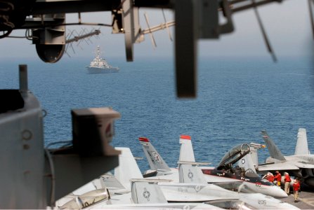 US Navy 070713-N-0890S-009 Guided-missile destroyer USS Higgins (DDG 76) steams behind nuclear-powered aircraft carrier USS Nimitz (CVN 68) while Sailors prepare for flight operations
