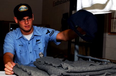 US Navy 070719-N-2143T-001 Storekeeper 2nd Class Ricky Mccaig, assigned to Bangor Naval Brig Correctional Custody Unit (CCU), inspects a Sailor's rack as part of daily routine for CCU awardees