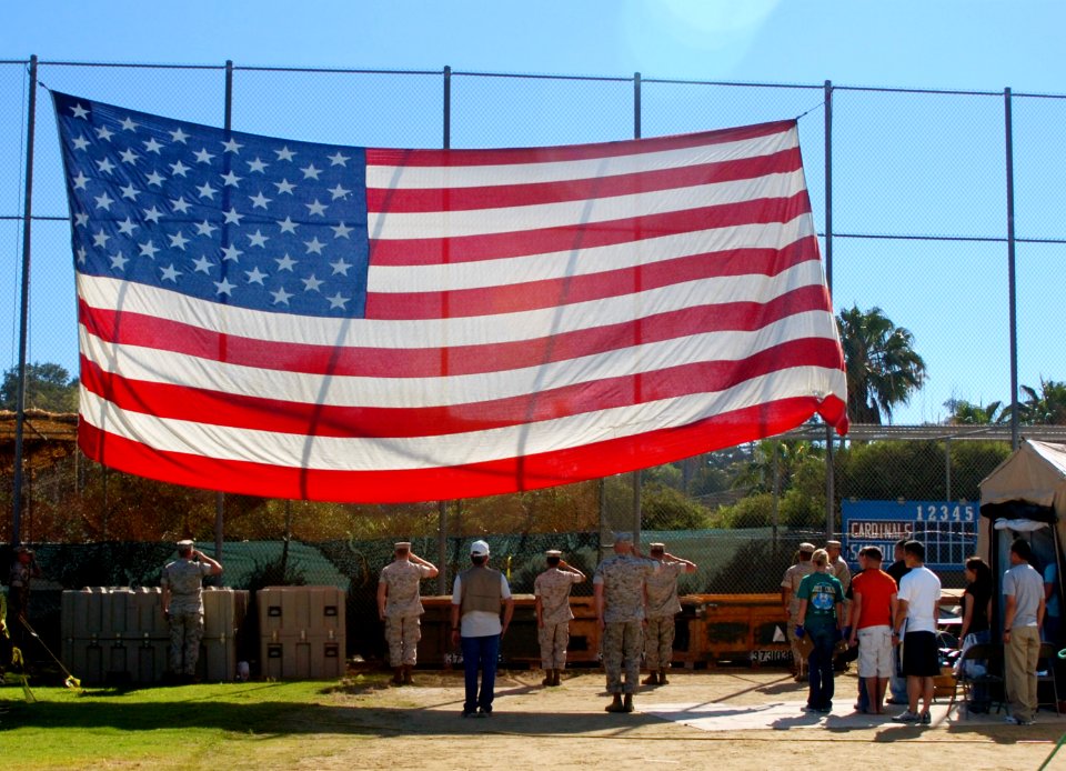 US Navy 070713-N-4163T-032 Military and civilian volunteers along with homeless veterans salute the U.S. flag during a rendition of The Star-Spangled Banner, during the 20th annual Stand Down for Homeless Veterans