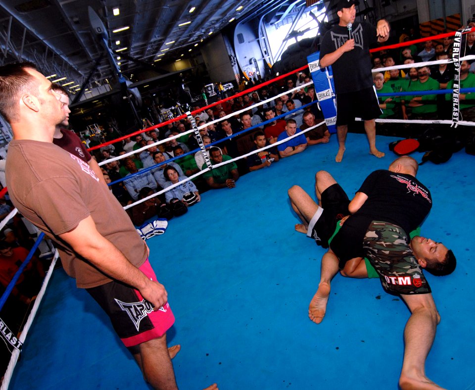 US Navy 070713-N-8923M-006 Ultimate Fighting Championship (UFC) fighter Mike Pyle demonstrates wrestling techniques on Storekeeper Seaman Anthony Aguilar before a crowd of Sailors
