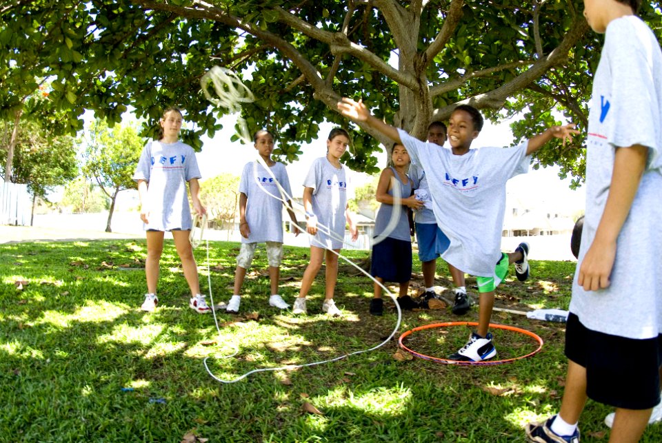 US Navy 070719-N-6674H-067 A child enrolled in the drug education for youth (DEFY) phase-one summer camp tosses a line to a volunteer mentor during a team building exercise at the Caitlin Community Center at Naval Station Pearl