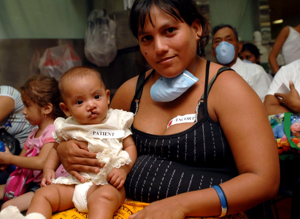 US Navy 070719-N-7088A-003 Sara Osego poses for a picture with her four-month-old baby after checking onto Military Sealift Command hospital ship USNS Comfort (T-AH 20) for cleft palette care
