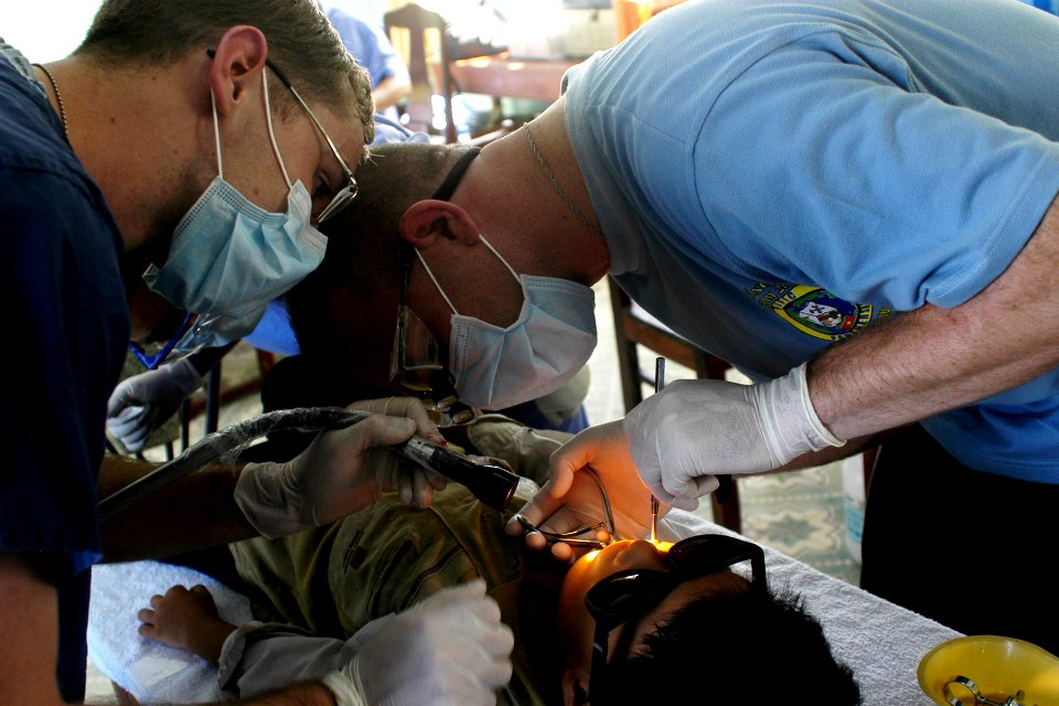 US Navy 070716-N-9195K-056 Lt. Kevin Haveman, assisted by Hospitalman Morgan Steel, performs an extraction on a local child during a dental civic action program conducted in support of Pacific Partnership 2007