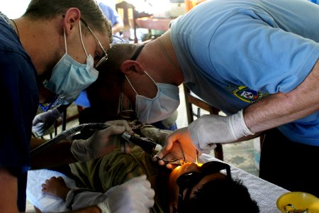US Navy 070716-N-9195K-056 Lt. Kevin Haveman, assisted by Hospitalman Morgan Steel, performs an extraction on a local child during a dental civic action program conducted in support of Pacific Partnership 2007