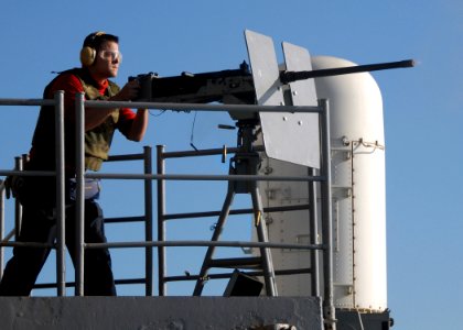 US Navy 070719-N-7981E-237 Aviation Ordnanceman Airman Jason Rowe fires a .50-caliber machine gun from the fantail of Nimitz-class aircraft carrier USS Abraham Lincoln (CVN 72) during a graded, live-fire killer barrel exercise photo