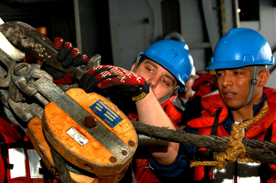 US Navy 070717-N-0455L-001 Boatswain's Mate 3rd Class Roger Silva supervises as Boatswain's Mate 3rd Class Kyle Coffrin hooks up the high line during an underway replenishment in the hangar bay aboard the Nimitz-class aircraft