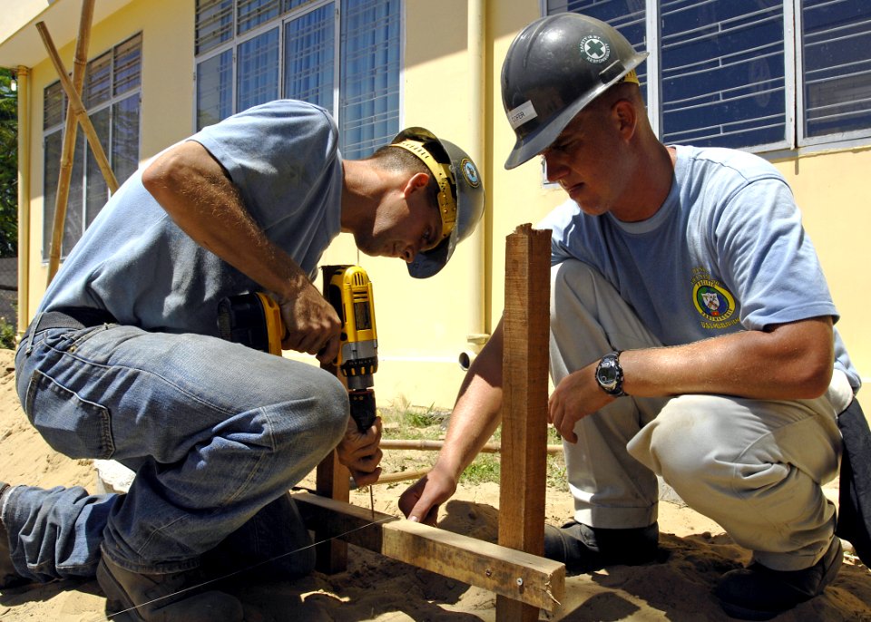 US Navy 070717-N-4954I-101 Steelworker 3rd Class Joseph Fleming and Equipment Operator Constructionman Ryan Cofer prepare footers for a playground kit to be installed on the campus of Hoi Mai Orphanage