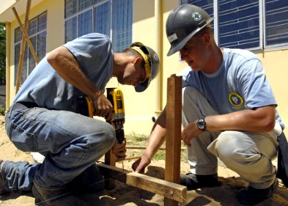 US Navy 070717-N-4954I-101 Steelworker 3rd Class Joseph Fleming and Equipment Operator Constructionman Ryan Cofer prepare footers for a playground kit to be installed on the campus of Hoi Mai Orphanage