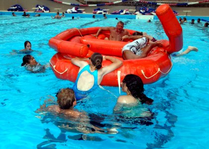 US Navy 070713-N-9758L-052 A Navy diver looks on as cadets from the Naval Junior Reserve Officer Training Corps attempt to enter a life raft for water survival training at Richardson Pool