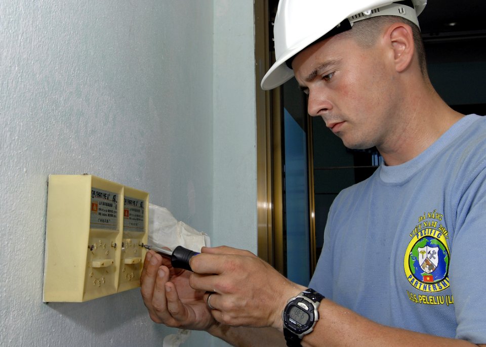 US Navy 070717-N-4954I-080 Hospital Corpsman 3rd Class James Wilson, with the 3rd Medical Battalion, unscrews a fan switch at Hoa Chau Medical Clinic in support of an engineering civil-action program