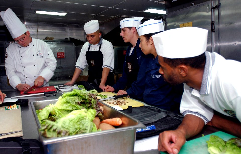 US Navy 070714-N-9150R-055 Culinary specialists watch as Executive Chef James Koskiniemi demonstrates his knife-handling skills aboard amphibious assault ship USS Boxer (LHD 4)