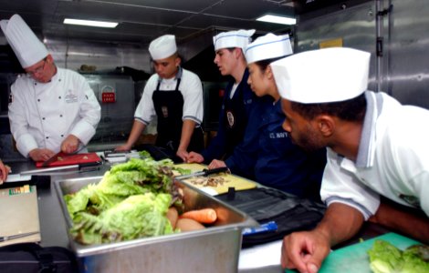 US Navy 070714-N-9150R-055 Culinary specialists watch as Executive Chef James Koskiniemi demonstrates his knife-handling skills aboard amphibious assault ship USS Boxer (LHD 4)