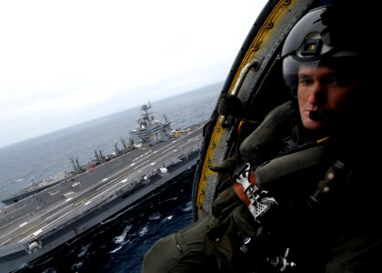 US Navy 070717-N-7981E-923 Aviation Warfare Systems Operator 2nd Class Patrick Treman, of the Golden Falcons of Helicopter Anti-submarine Squadron (HS) 2, acts as crew chief of an HH-60H Seahawk