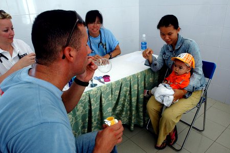 US Navy 070717-N-9421C-053 Information Systems Technician 2nd Class Donald Seaux amuses a Vietnamese baby by blowing bubbles at Ngu Hanh Son District Medical Center