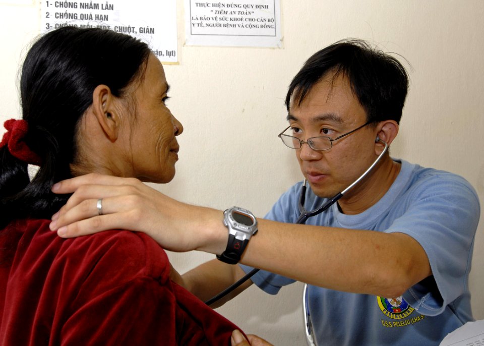 US Navy 070720-N-4954I-033 Volunteer doctor Capt. Yehudi Yeo, with the Singapore navy, listens to a Vietnamese patient's breathing pattern at the Man Thai Ward Medical Station