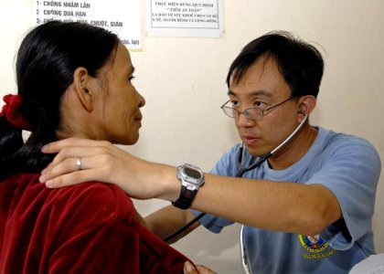US Navy 070720-N-4954I-033 Volunteer doctor Capt. Yehudi Yeo, with the Singapore navy, listens to a Vietnamese patient's breathing pattern at the Man Thai Ward Medical Station