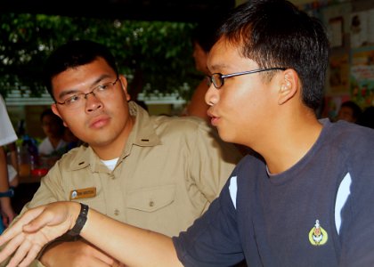US Navy 070719-N-0120A-057 Dock landing ship USS Harpers Ferry (LSD 49) Sailor talks to a Singapore navy sailor during a community interaction project at a Movement for the Intellectually Disabled of Singapore (MINDS) training