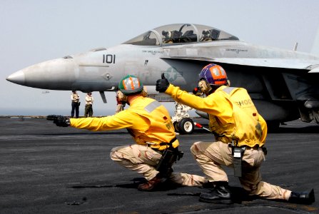 US Navy 070720-N-8119R-040 Lt. Eric Walborn and Lt. Reynaldo Stanley give the signal to launch an F-A-18F Super Hornet, assigned to the Black Aces of Strike Fighter Squadron (VFA) 41, from nuclear-powered aircraft carrier USS