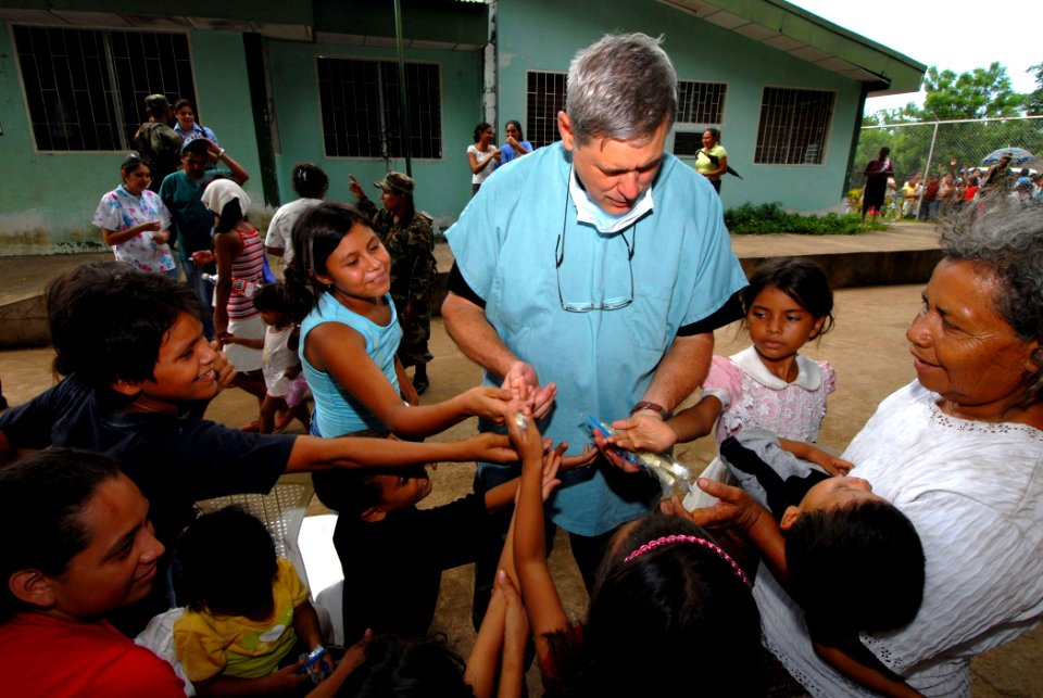 US Navy 070720-N-8704K-144 U.S. National Guard Lt. Col. Richard Tate, attached to the Military Sealift Command hospital ship USNS Comfort (T-AH 20), hands out toothbrushes to children at the 15 de Julio Health Care Center