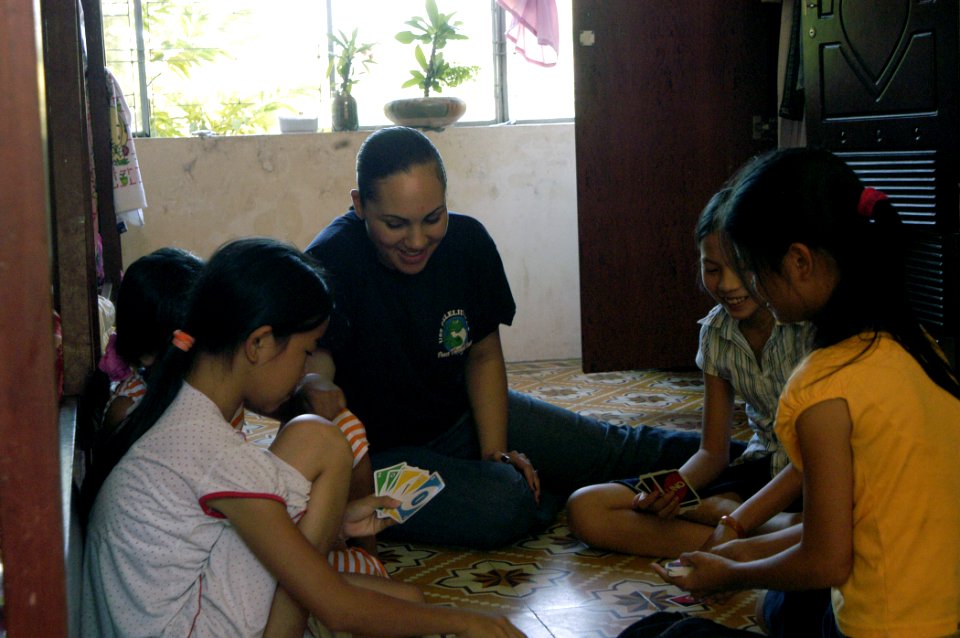 US Navy 070719-N-6999H-009 Storekeeper 3rd Class Julie Henderson plays a card game with four Vietnamese children while visiting Hoi Mai Orphanage center