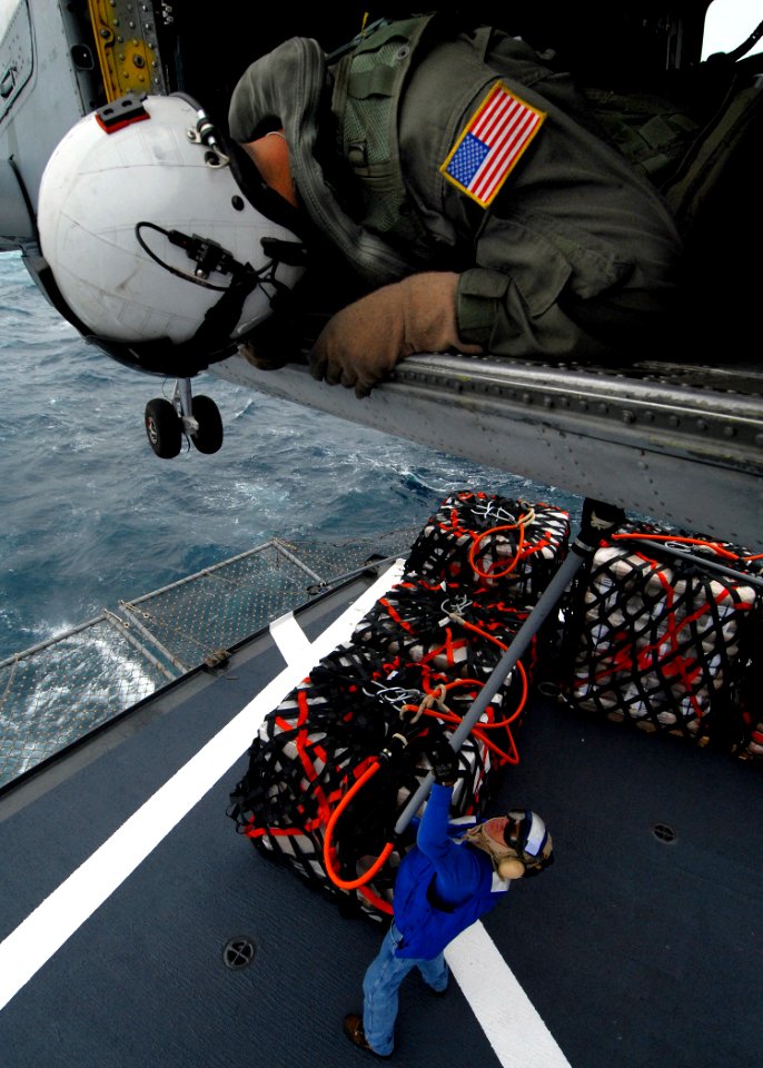 US Navy 070717-N-7981E-161 Aviation Warfare Systems Operator 2nd Class Tyler Yee, of the Golden Falcons of Helicopter Anti-submarine Squadron (HS) 2, relays information to the pilots of an HH-60H Seahawk